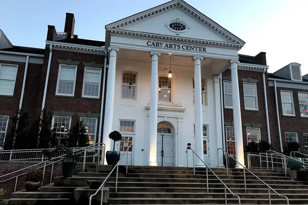 White-columned portico and brick wings of the Cary Arts Center at dusk in Cary, North Carolina