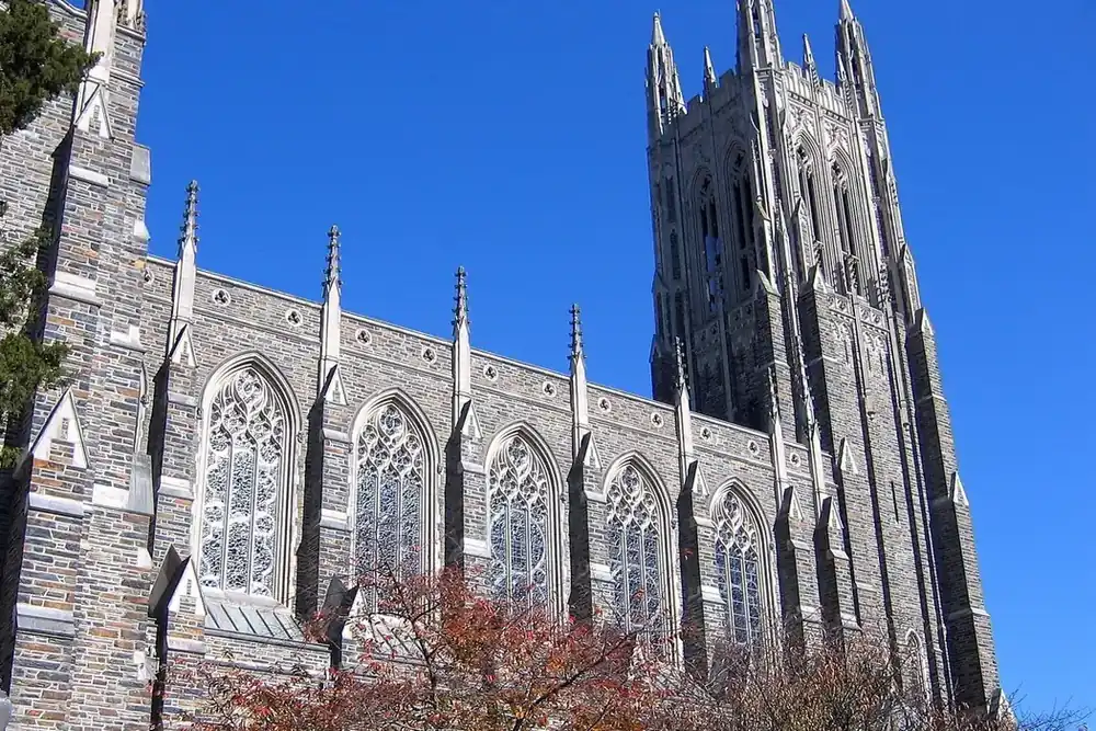 Gothic stone walls, tall windows and bell tower of Duke Chapel in Durham, North Carolina